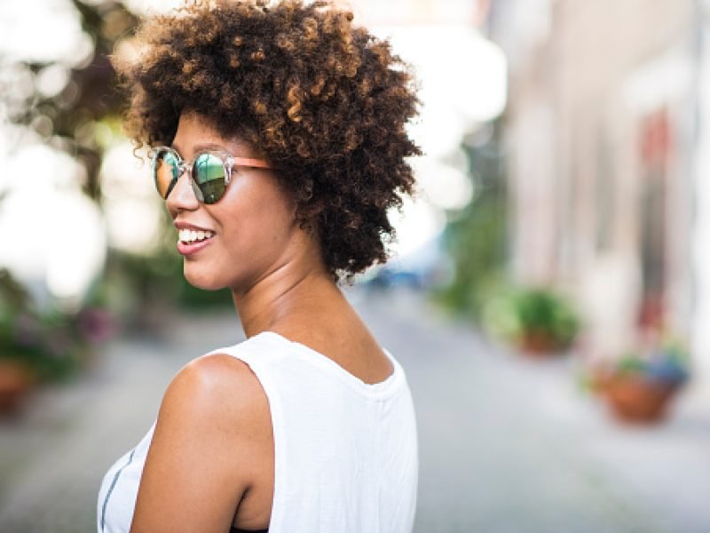 A young African American woman smiling in the city